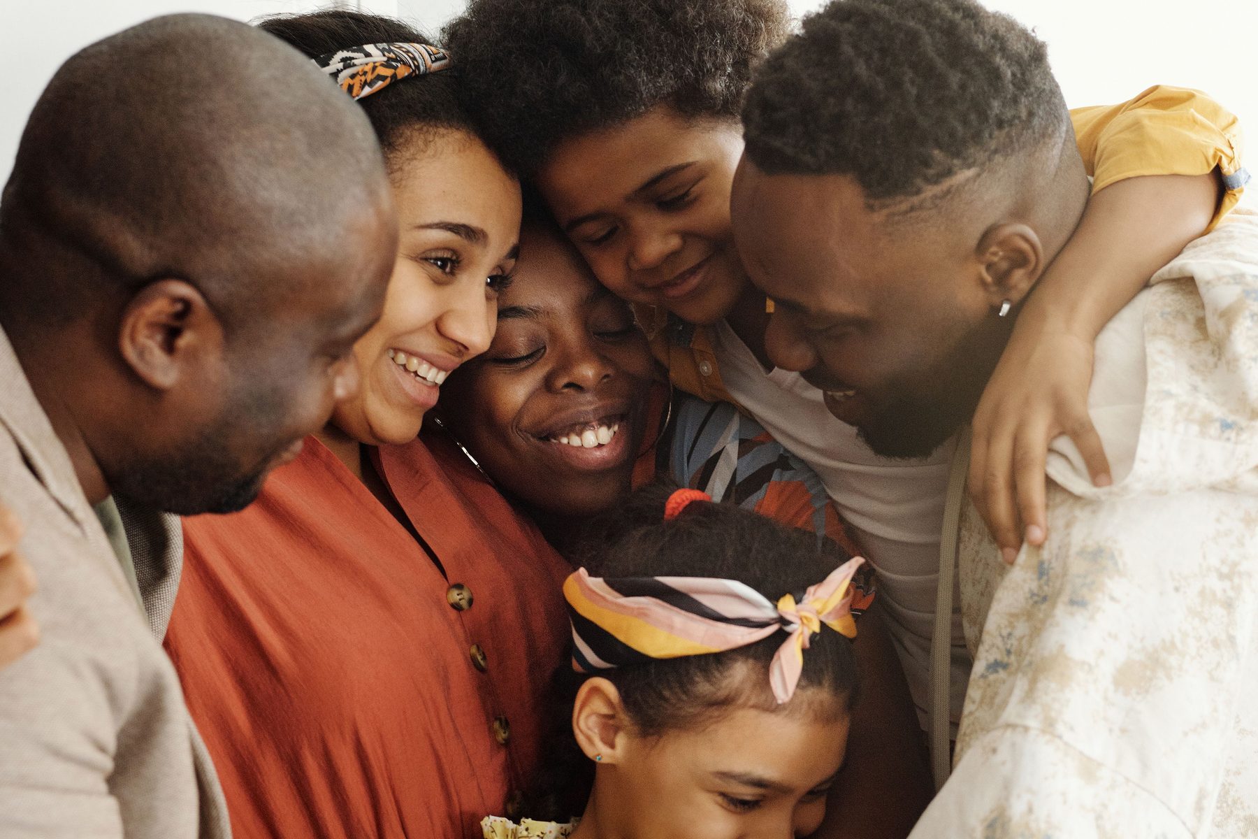 A family of six embracing together, smiling.